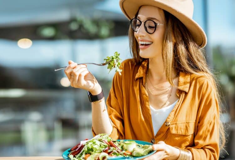 Woman eating salad on a cafe terrace