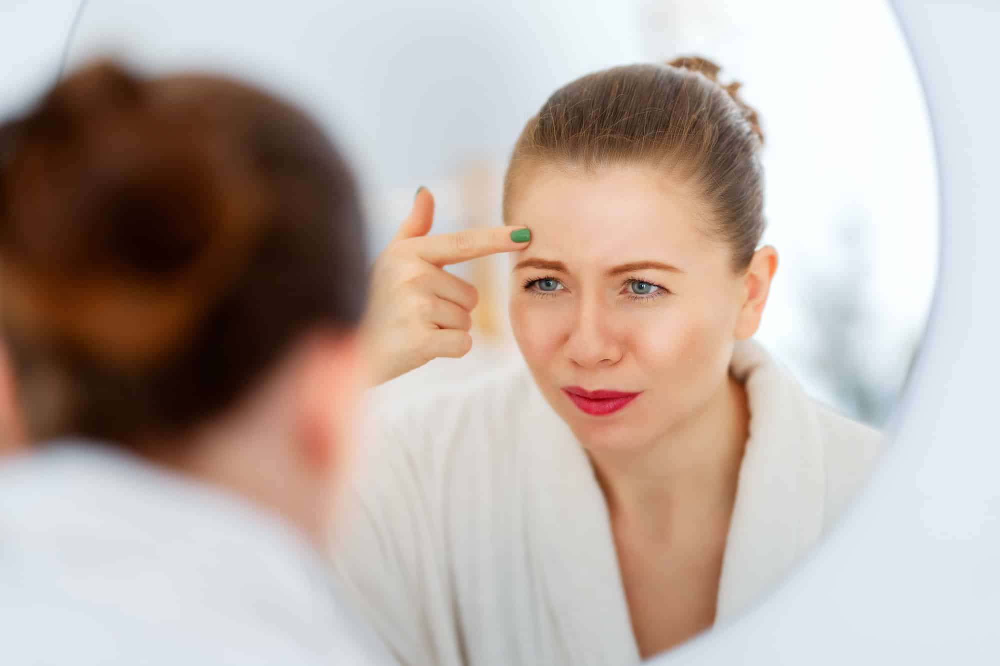 woman looking at wrinkles