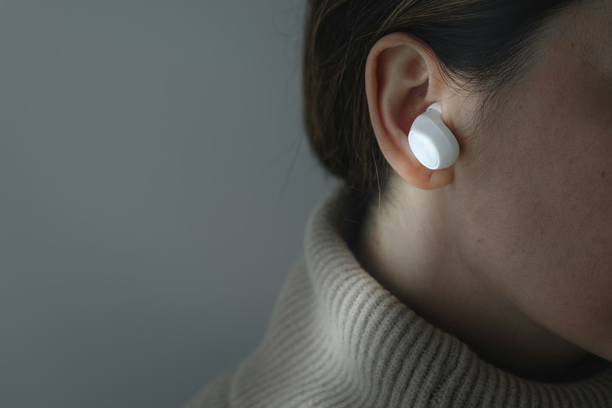 Woman wearing white wireless earbuds