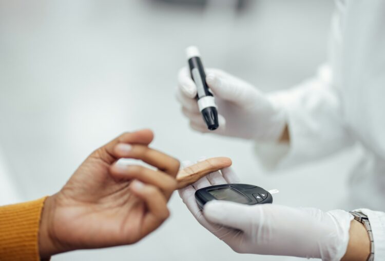 Close-up image of a doctor using blood glucose test kit.