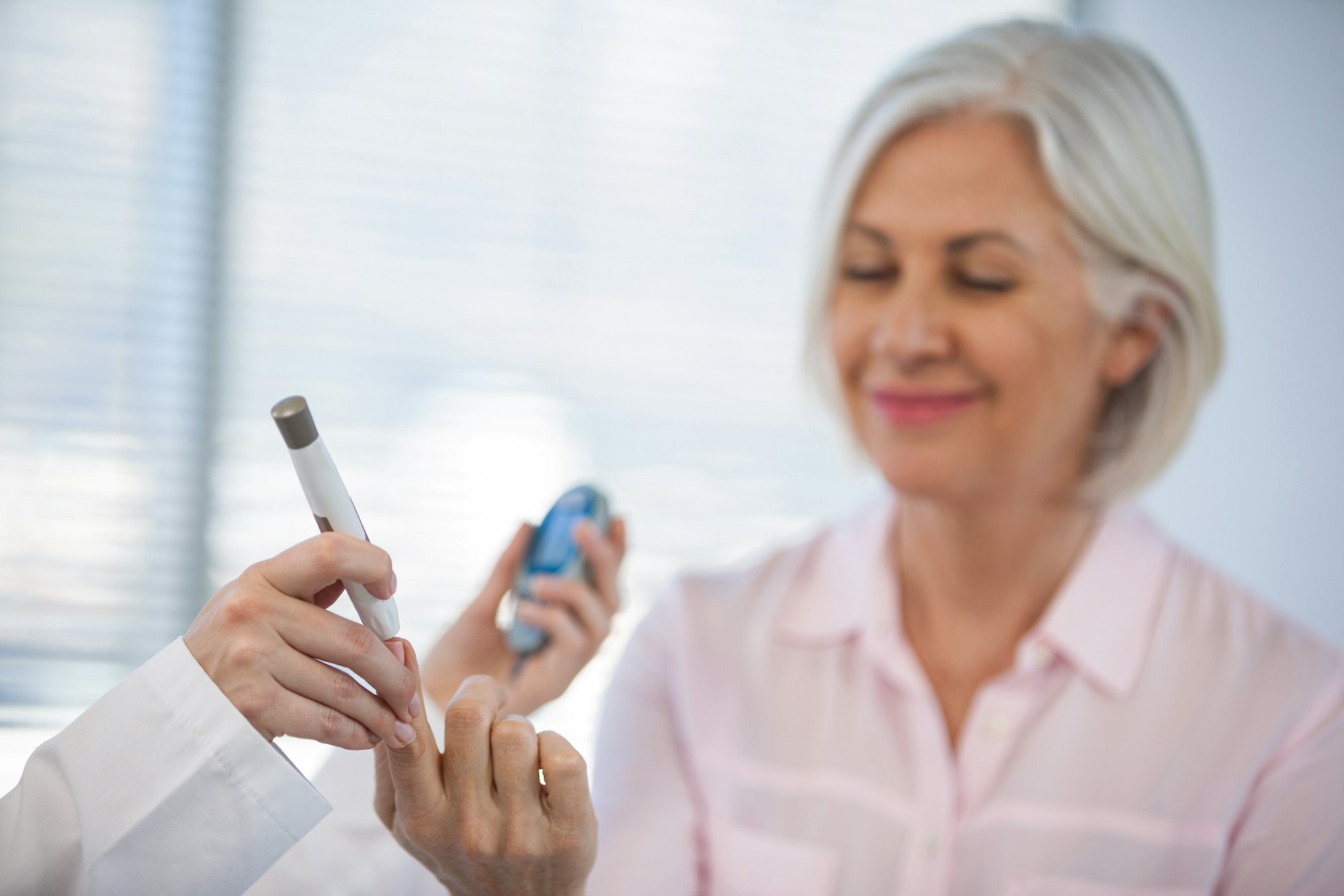 Doctor checking glucose level in diabetic patient